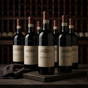 Wijnflessen met Dolcetto-, Barbera- en Nebbiolo-etiketten in een sfeervolle wijnkelder.